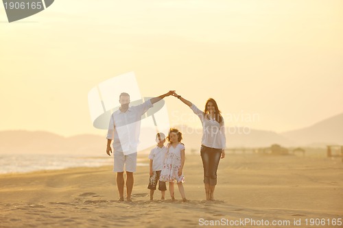 Image of happy young family have fun on beach at sunset