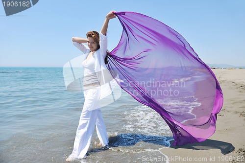 Image of beautiful young woman on beach with scarf