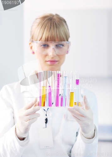 Image of female researcher holding up a test tube in lab