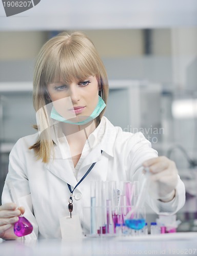 Image of female researcher holding up a test tube in lab