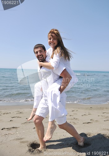 Image of happy young couple have fun on beach