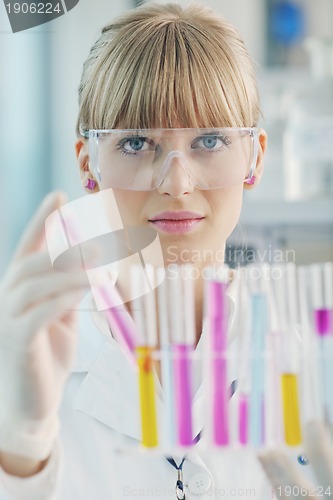 Image of female researcher holding up a test tube in lab