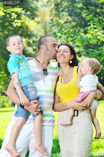 Image of happy young couple with their children have fun at park