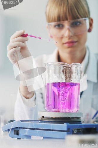 Image of female researcher holding up a test tube in lab