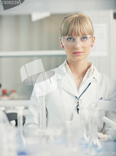 Image of female researcher holding up a test tube in lab