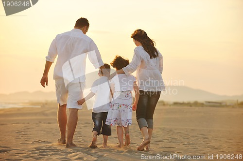 Image of happy young family have fun on beach at sunset