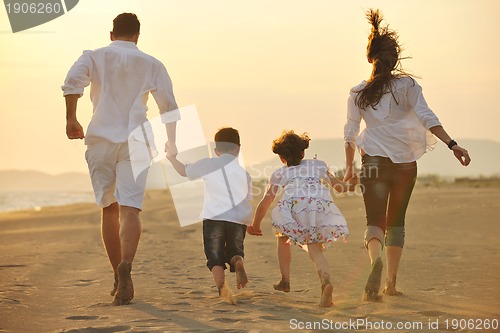 Image of happy young family have fun on beach at sunset