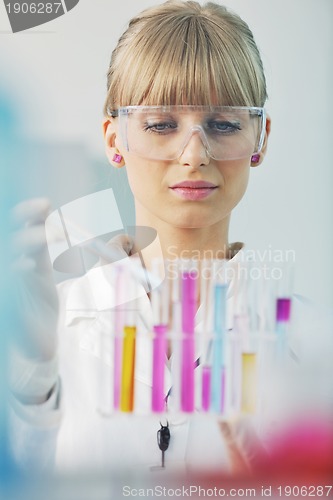 Image of female researcher holding up a test tube in lab