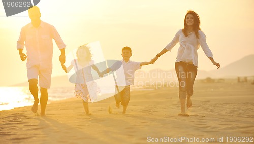 Image of happy young family have fun on beach at sunset
