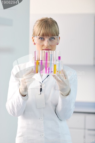 Image of female researcher holding up a test tube in lab