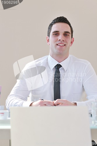 Image of young business man alone in conference room