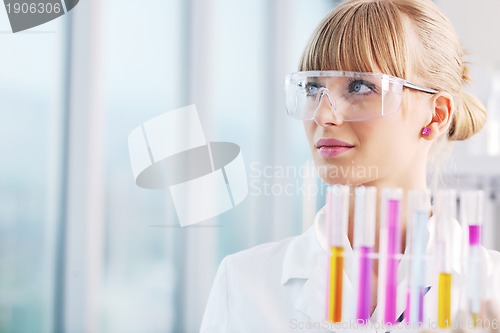 Image of female researcher holding up a test tube in lab