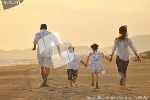 Image of happy young family have fun on beach at sunset
