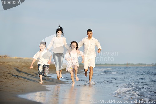 Image of happy young family have fun on beach at sunset