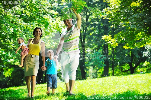 Image of happy young couple with their children have fun at park