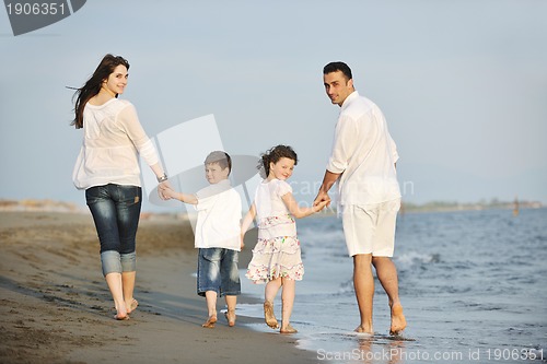 Image of happy young family have fun on beach at sunset