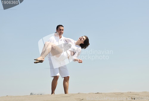 Image of happy young couple have fun on beach