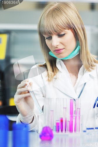 Image of female researcher holding up a test tube in lab