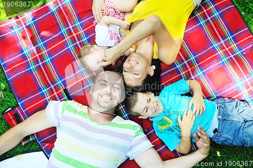 Image of happy young couple with their children have fun at park