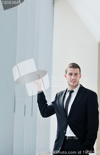 Image of young business man alone in conference room