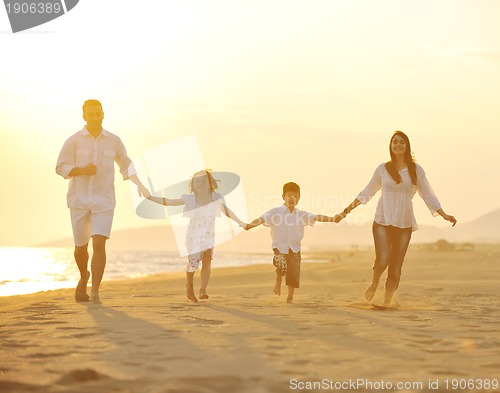 Image of happy young family have fun on beach at sunset