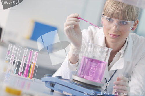 Image of female researcher holding up a test tube in lab