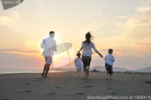 Image of happy young family have fun on beach at sunset
