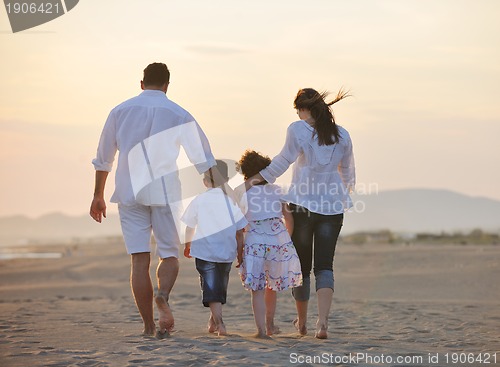Image of happy young family have fun on beach at sunset