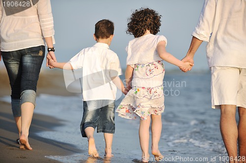 Image of happy young family have fun on beach at sunset