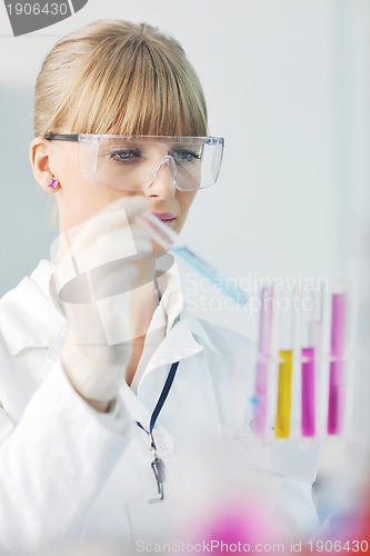 Image of female researcher holding up a test tube in lab