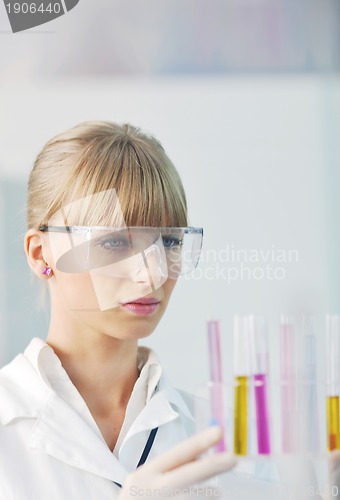 Image of female researcher holding up a test tube in lab