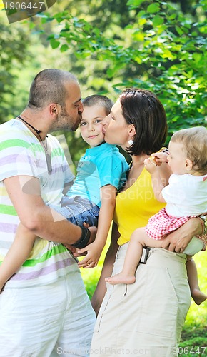 Image of happy young couple with their children have fun at park