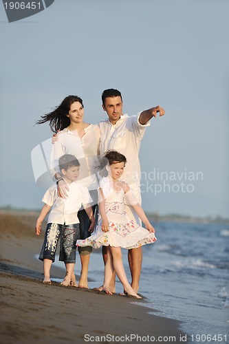 Image of happy young family have fun on beach at sunset