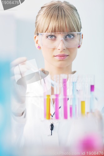 Image of female researcher holding up a test tube in lab