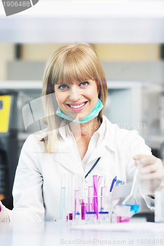 Image of female researcher holding up a test tube in lab