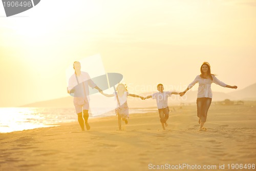 Image of happy young family have fun on beach at sunset