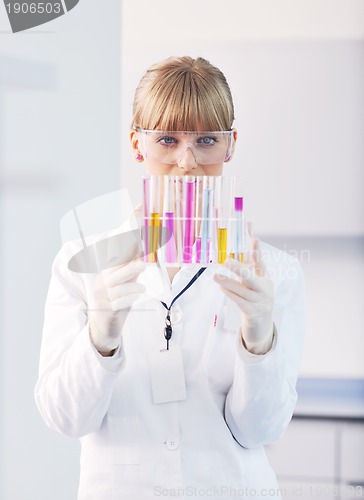 Image of female researcher holding up a test tube in lab