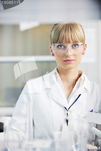 Image of female researcher holding up a test tube in lab