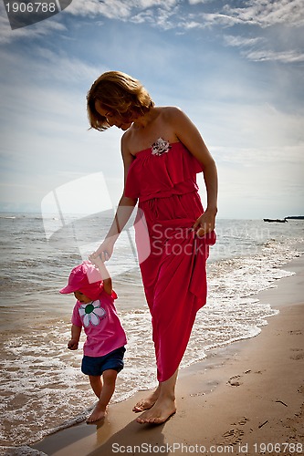 Image of Mother with her baby  having fun on the beach
