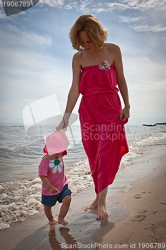 Image of Mother with her baby  having fun on the beach