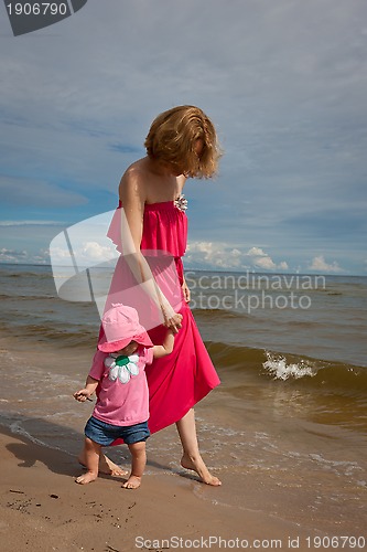 Image of Mother with her baby  having fun on the beach