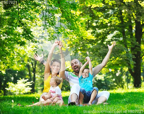 Image of happy young couple with their children have fun at park
