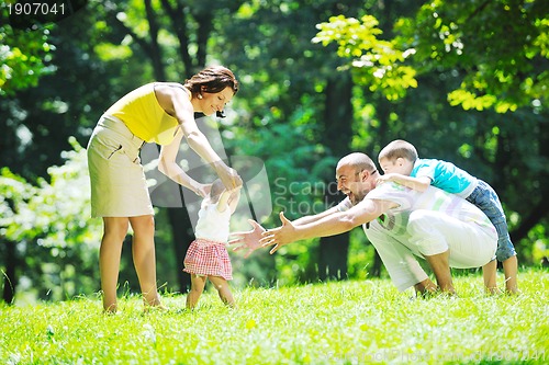 Image of happy young couple with their children have fun at park