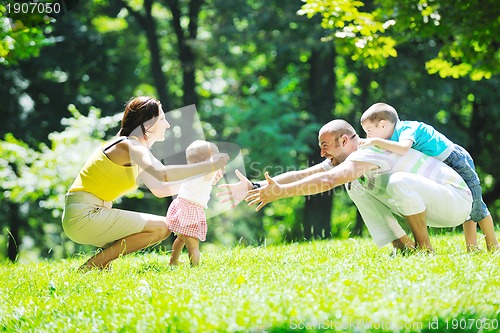Image of happy young couple with their children have fun at park