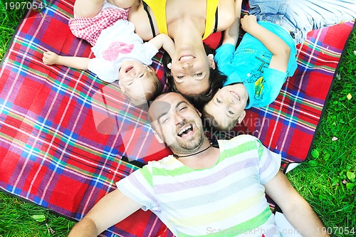 Image of happy young couple with their children have fun at park