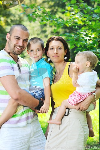 Image of happy young couple with their children have fun at park