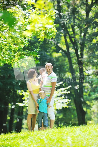 Image of happy young couple with their children have fun at park