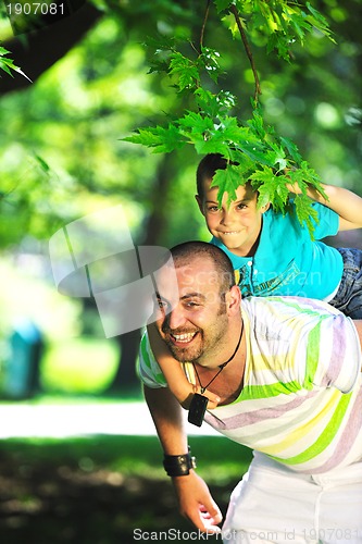 Image of happy father and son have fun at park