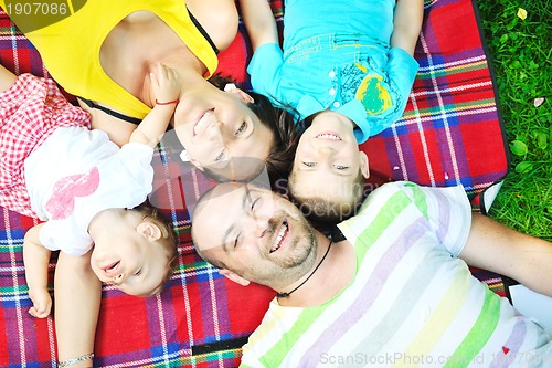 Image of happy young couple with their children have fun at park
