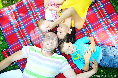 Image of happy young couple with their children have fun at park